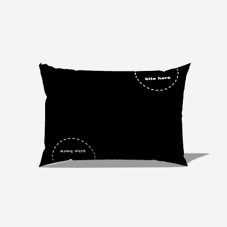 Photo of a small lumbar pillow with the words "bite here" on one corner.